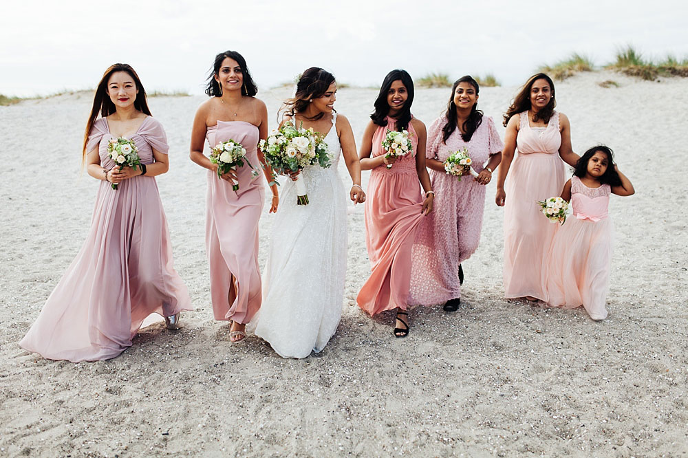 bride and bridesmaids walking on the beach in Copenhagen