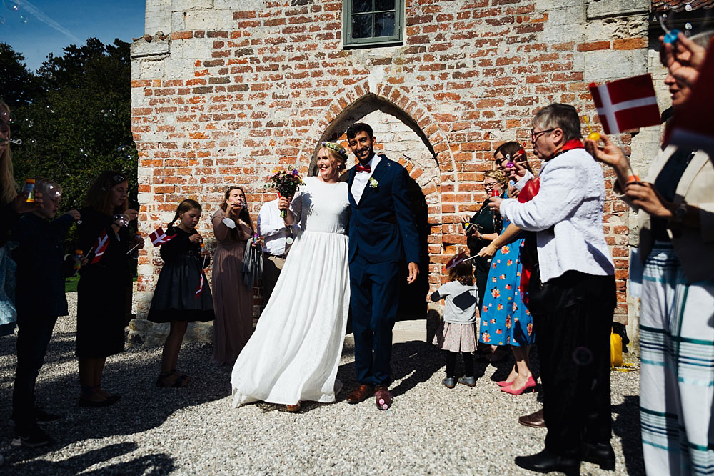 bride and groom leaving the church in Stevns Klint after their wedding ceremony