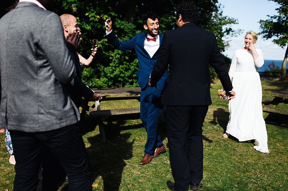 groom dancing with guests at his open air wedding in Stevns Klint, Denmark