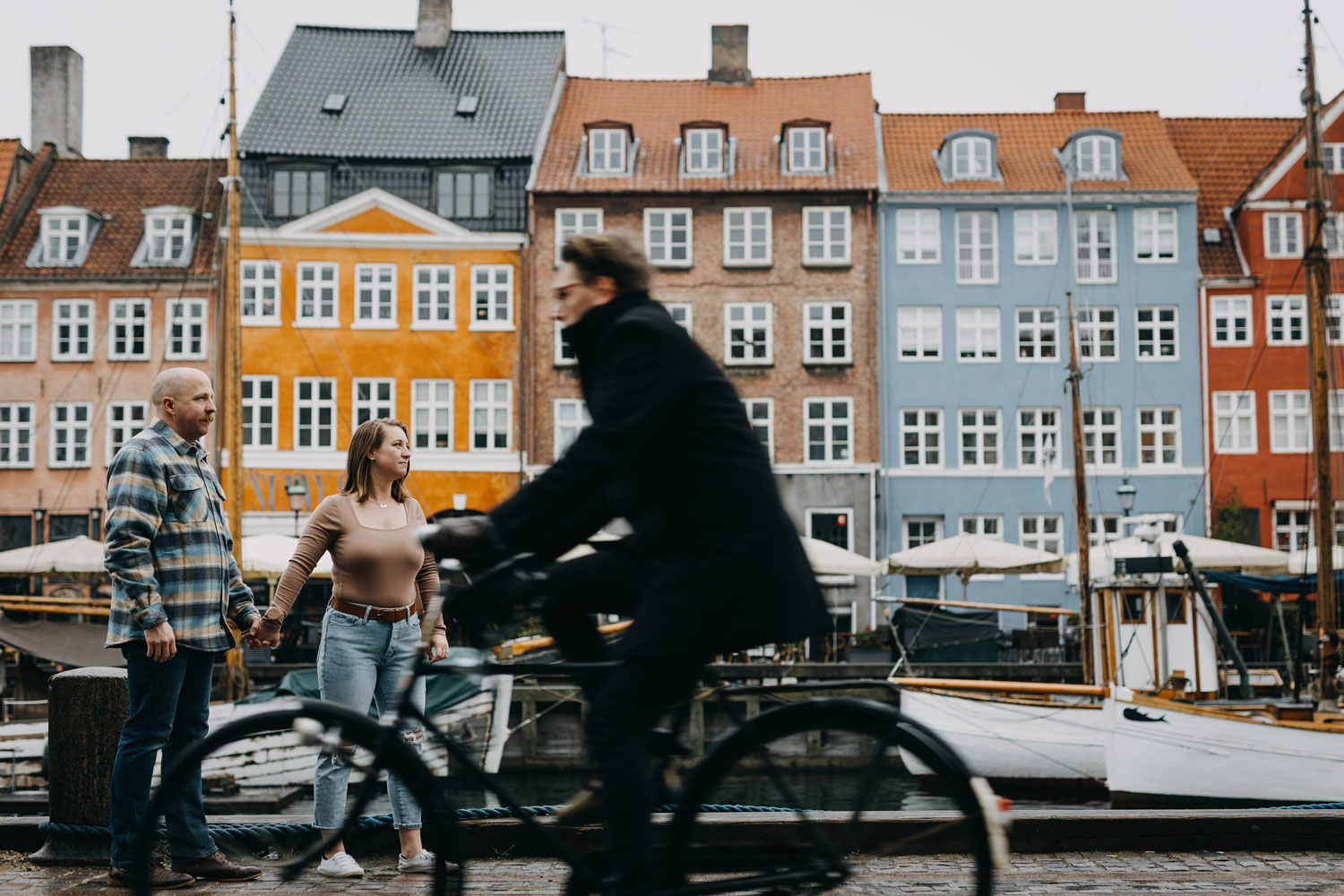 couple posing in front of colourful facades of Copenhagen's buildings