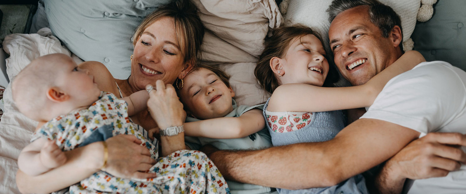 Copenhagen family photographer captures heartwarming moments of a family cuddling at home in Østerbro