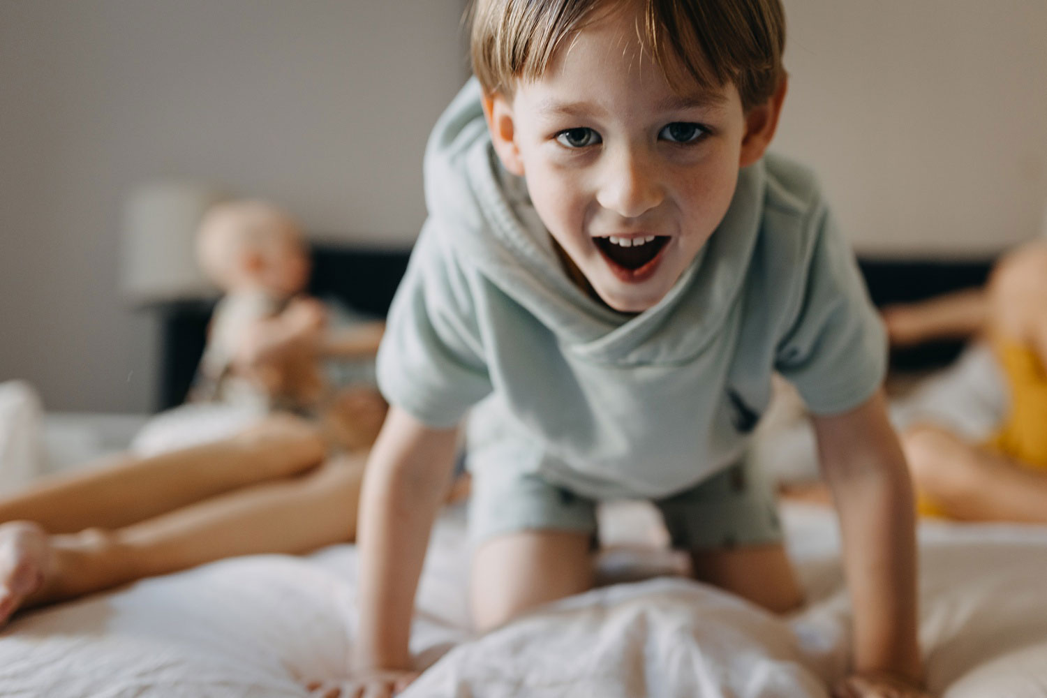 toddler playing on parents bed at their home in Copenhagen