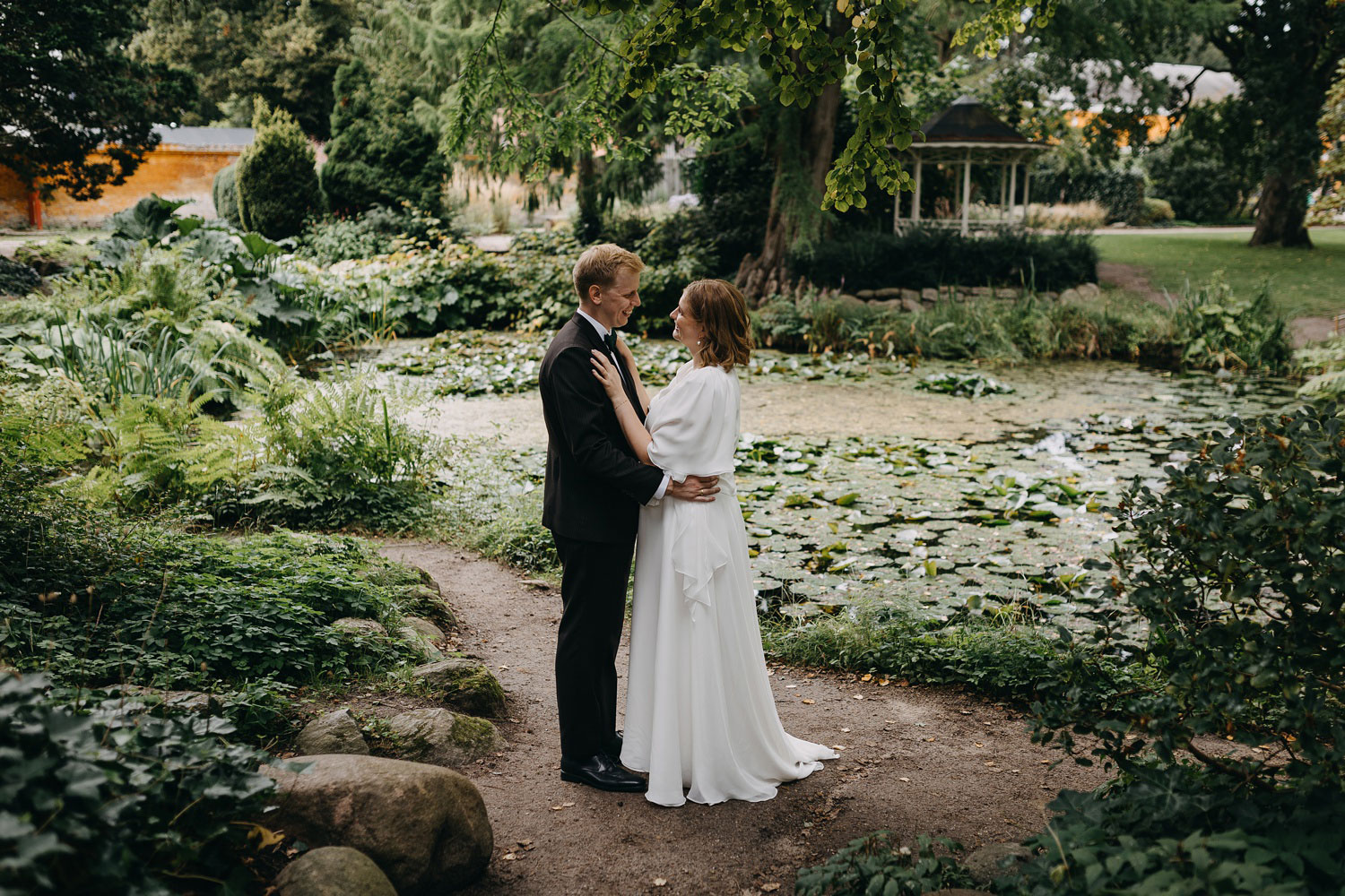 Newlywed couple embracing under the trees at Frederiksberg Have, Copenhagen