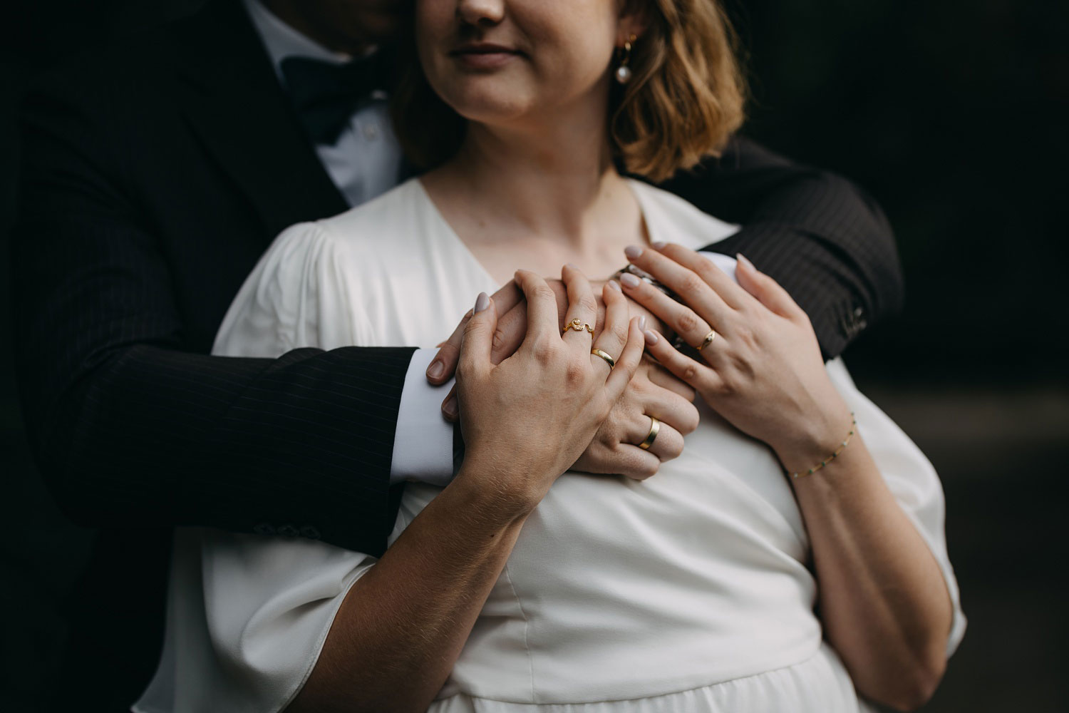 Close-up of the newlyweds' intertwined hands, showcasing their wedding rings, in Copenhagen