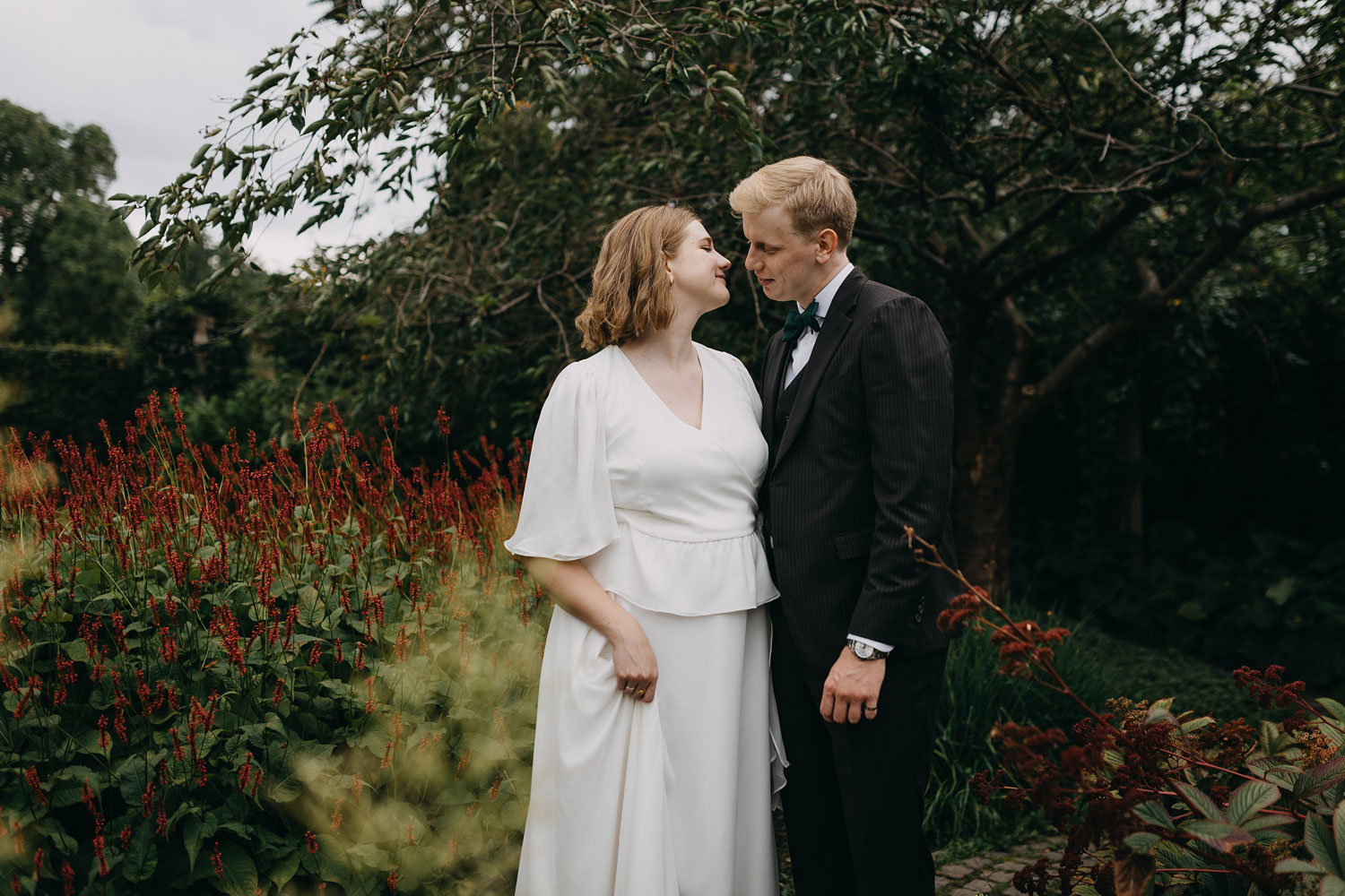 Newly married couple sharing a loving glance in the idyllic surroundings of Frederiksberg Have, Copenhagen