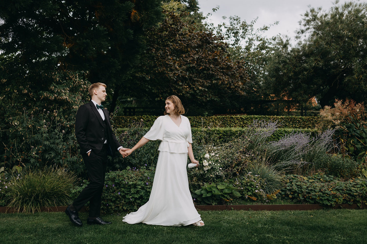 Happily married couple capturing a beautiful memory amidst the greenery of Frederiksberg Have