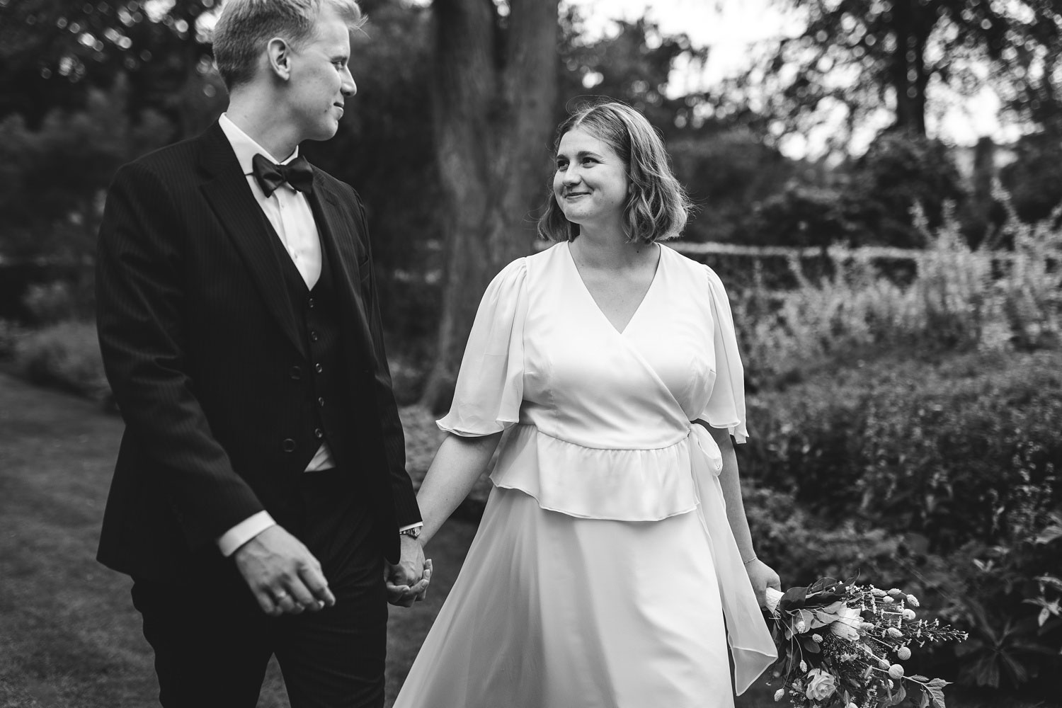 Newly married couple sharing a loving glance in the idyllic surroundings of Frederiksberg Have, Copenhagen