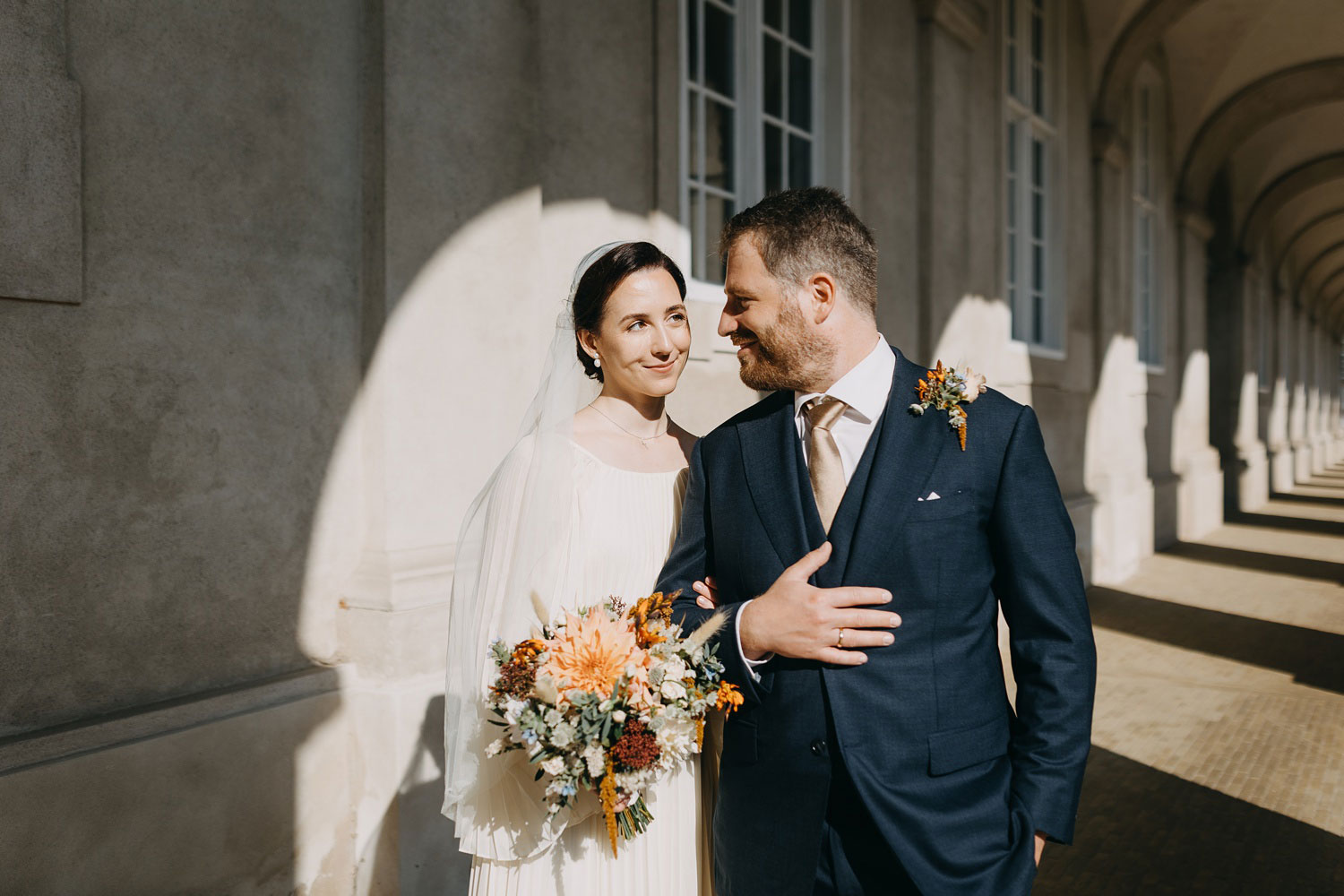 bride and groom outside Copebride and groom posing for wedding portraits at Christiansborg Slot in Copenhagen