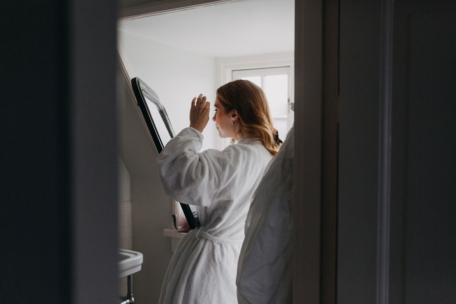 bride getting ready and looking herself in the mirror 