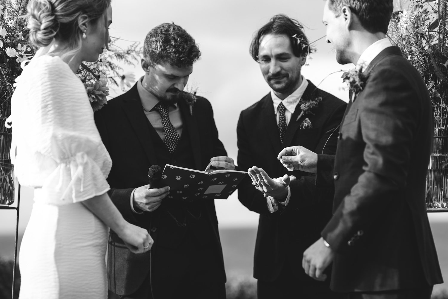 the bride and groom lovingly exchange rings during their wedding ceremony at Helenekilde