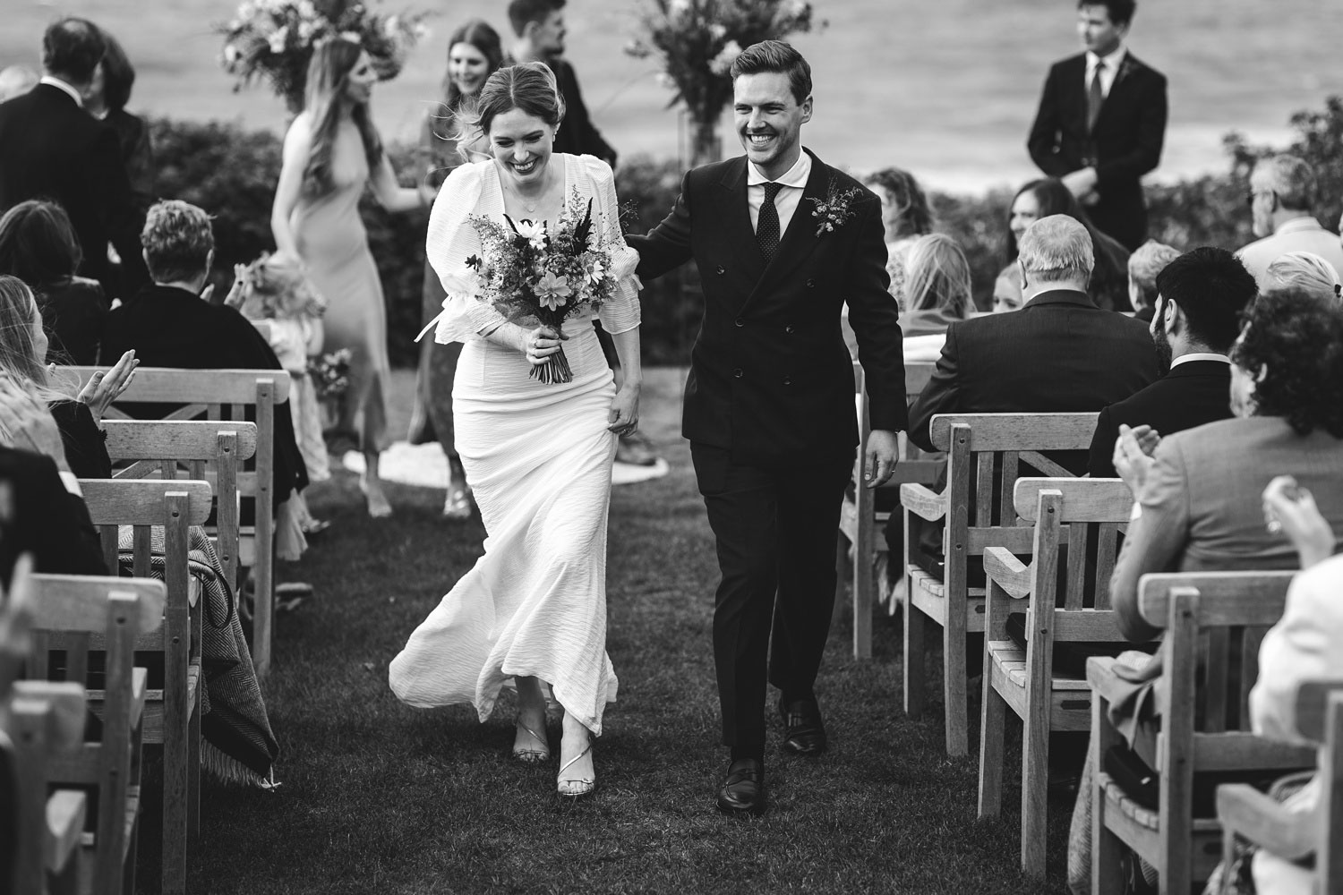 the bride and groom exit the ceremony venue, hand in hand, at Helenekilde Badehotel, Tisvildeleje, Denmark