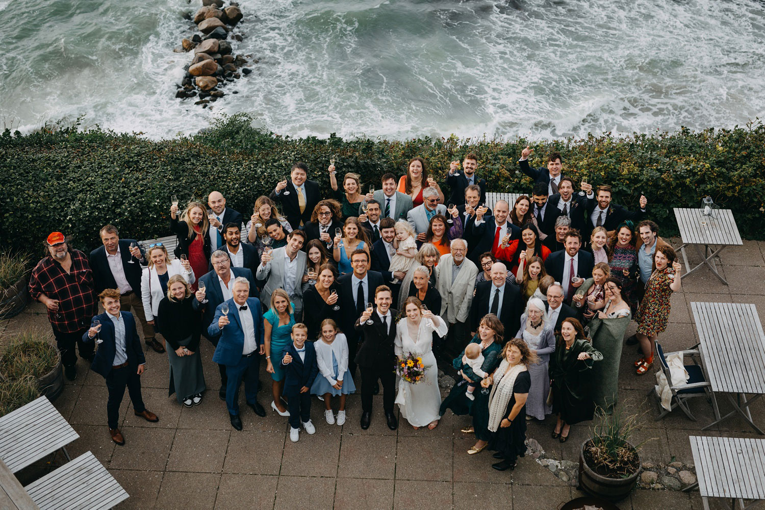 Celebratory atmosphere in a group photo featuring the bride, groom, and their loved ones at Helenekilde Badehotel