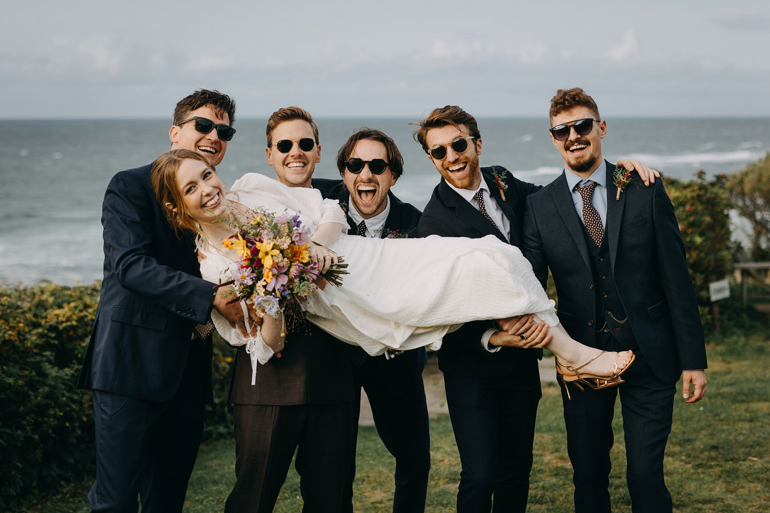 best men carrying the bride for a fun shot