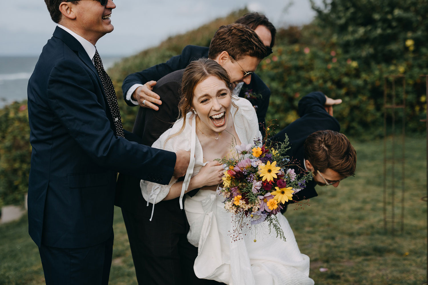 best men carrying the bride for a fun shot