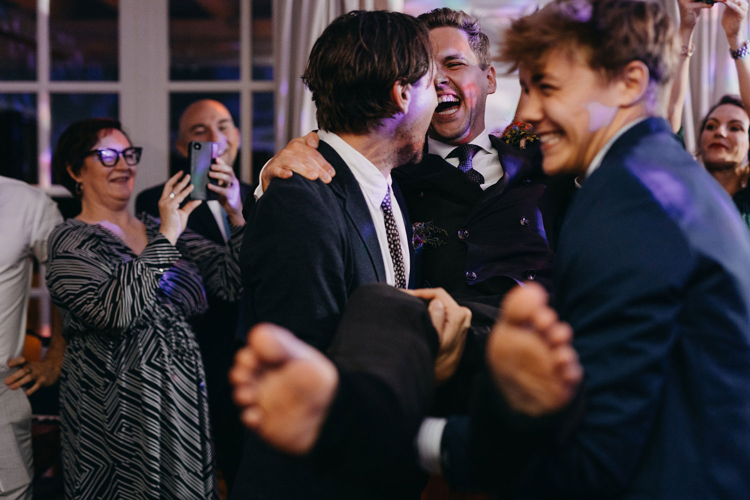 capturing the groom's reaction as part of the sock-cutting tradition at Helenekilde 