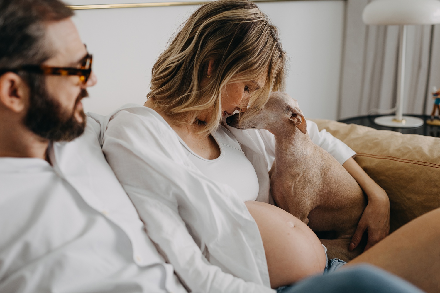 A beautiful home maternity session featuring a couple and their charming Italian Greyhounds