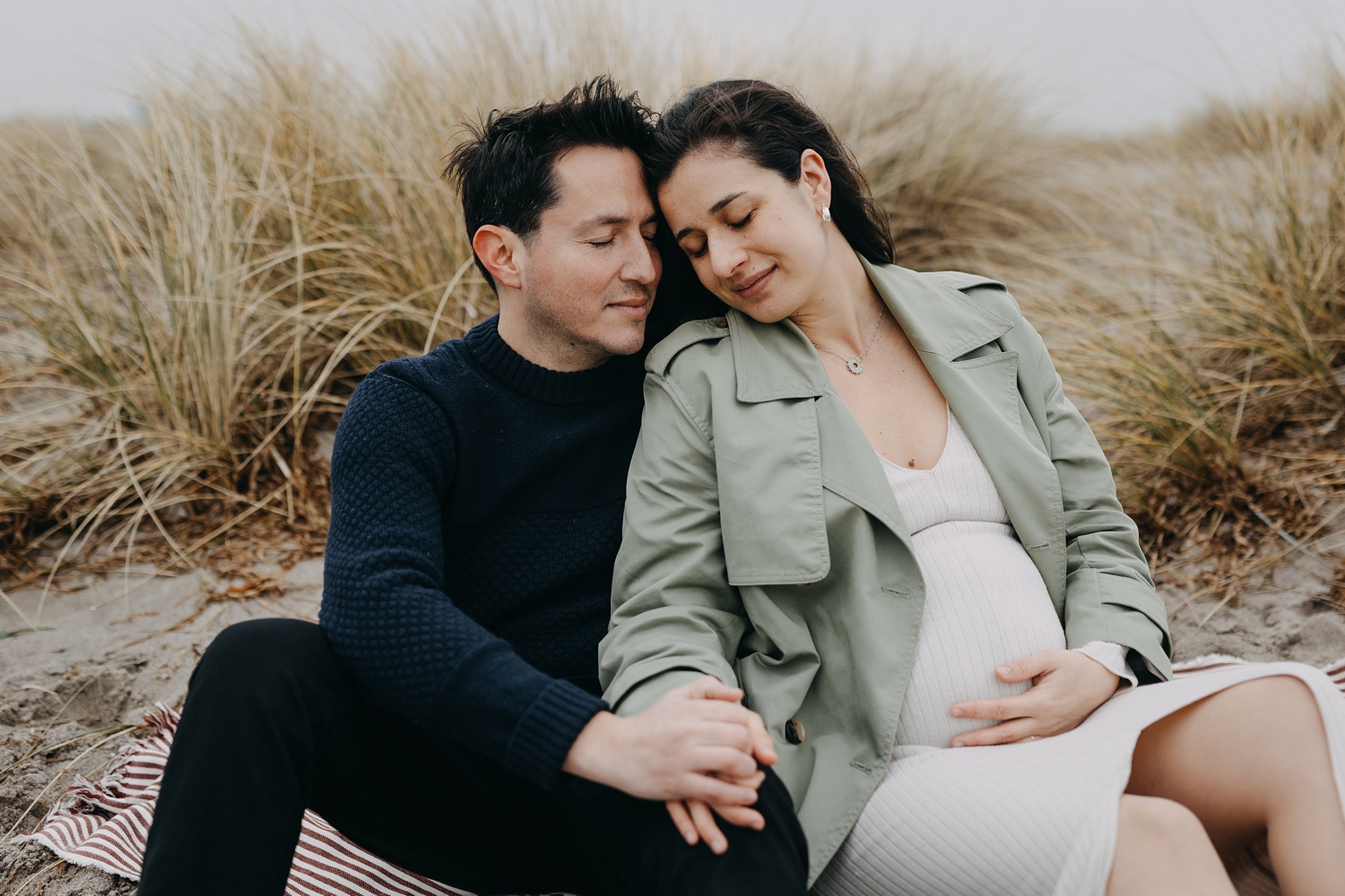 Expecting couple embracing at Amager Strand