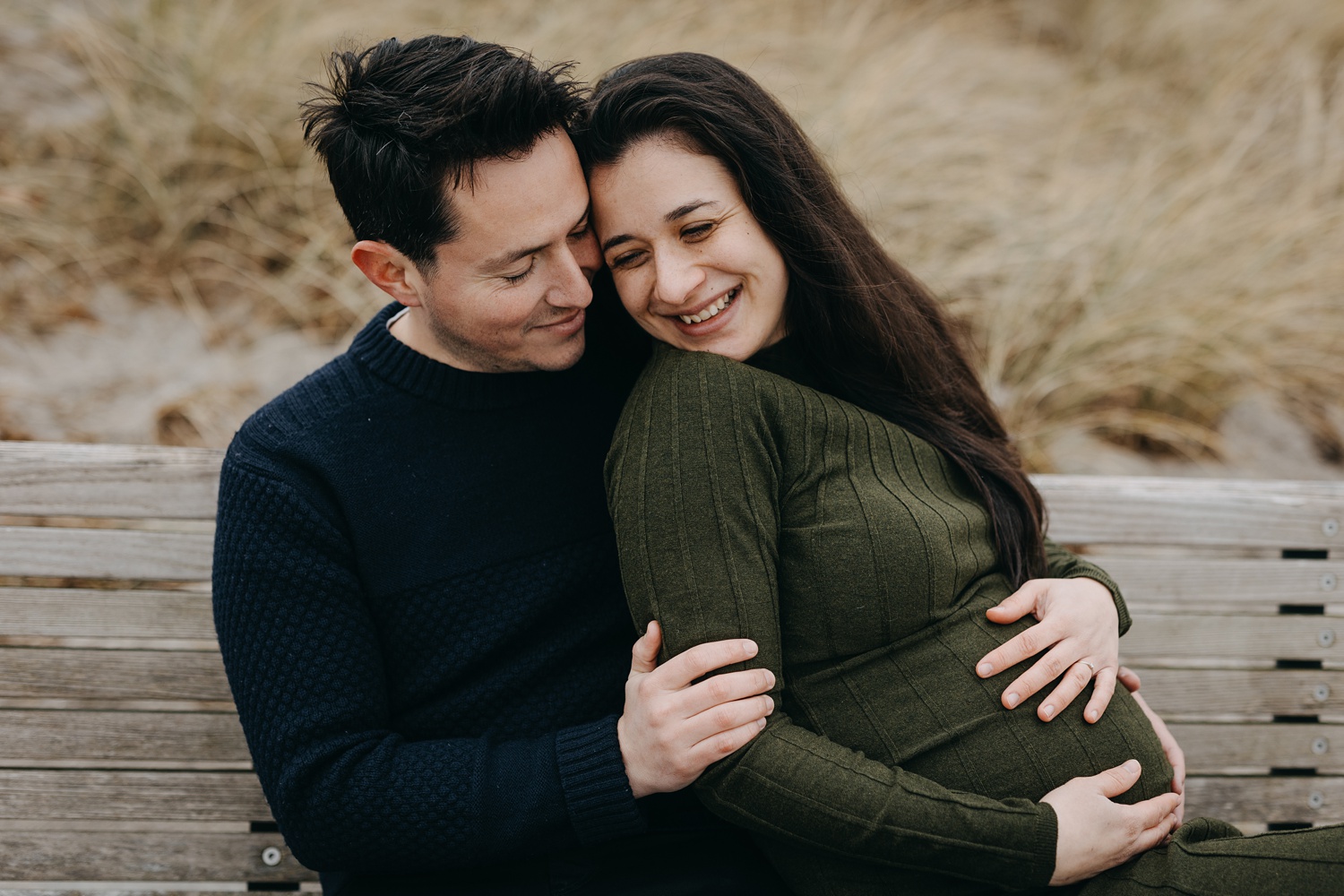 Expecting couple embracing at Amager Strand