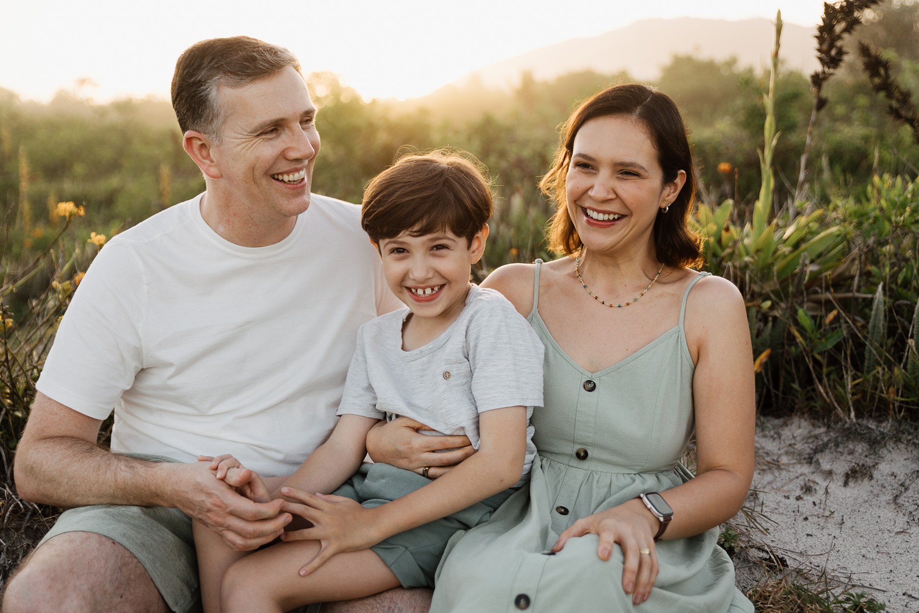Natural family photo session at the beach with soft sunset light and sand dunes in Florianópolis