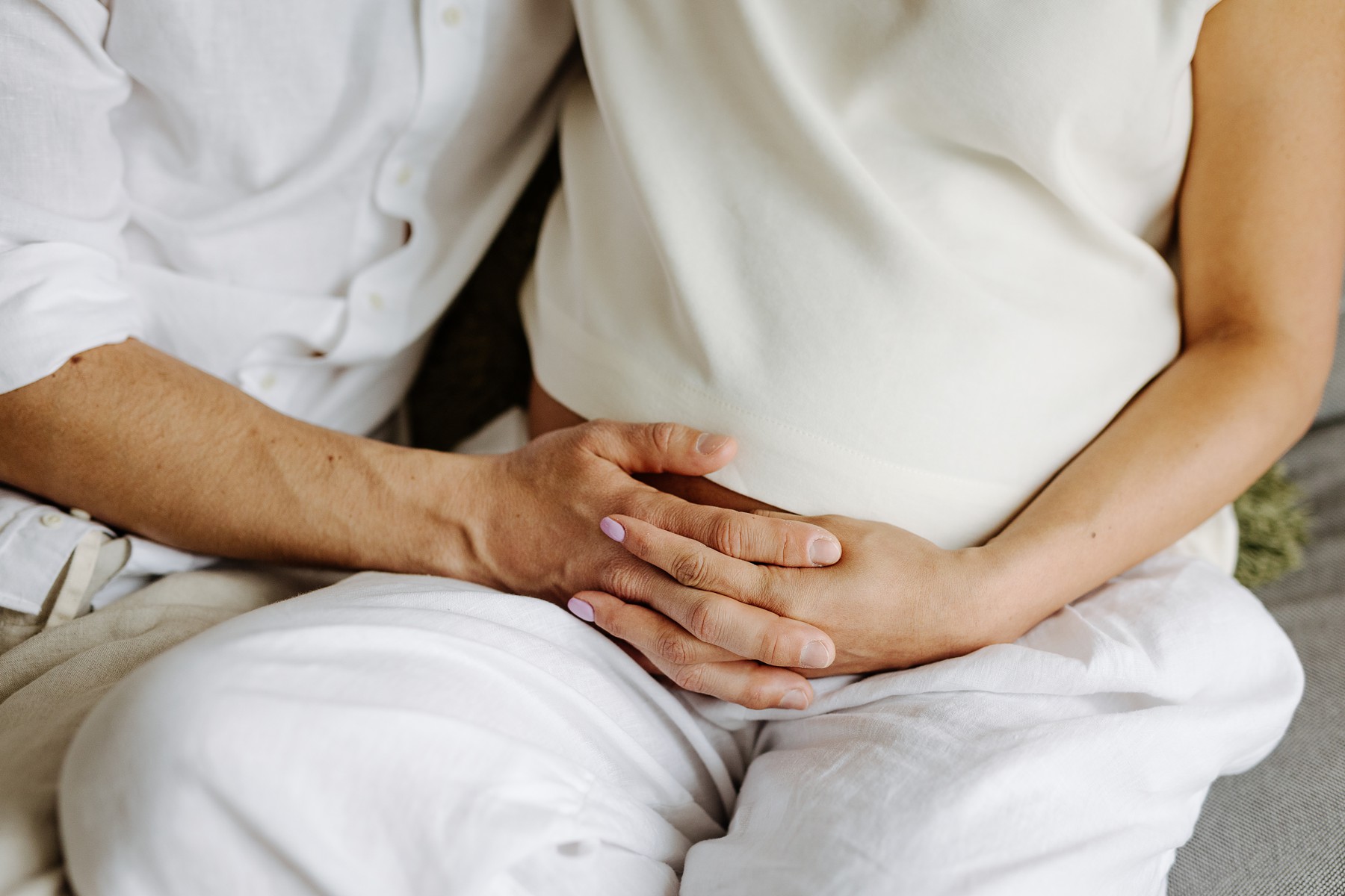 Close-up of couple's hands on a pregnant belly 