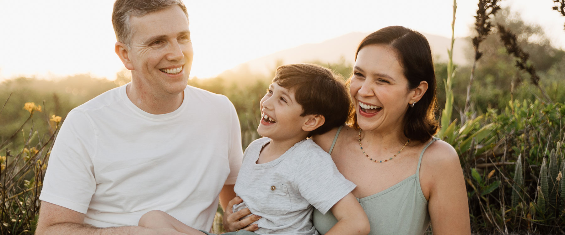 Natural family photo session at the beach with soft sunset light and sand dunes in Florianópolis