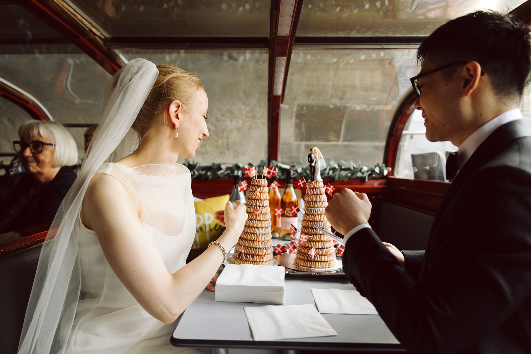 bride and groom cutting the wedding cake and enjoying a canal boat tour through Copenhagen 