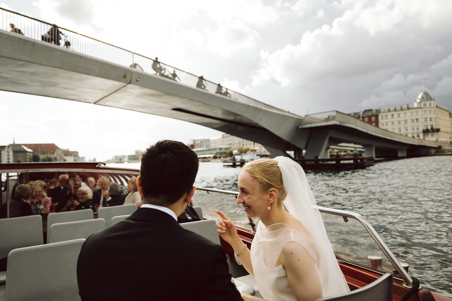 Copenhagen wedding canal boat tour with bride and groom passing under the kissing bridge