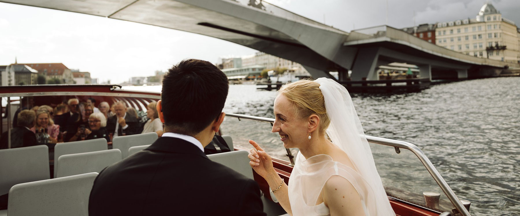 Copenhagen wedding canal boat tour with bride and groom passing under the kissing bridge