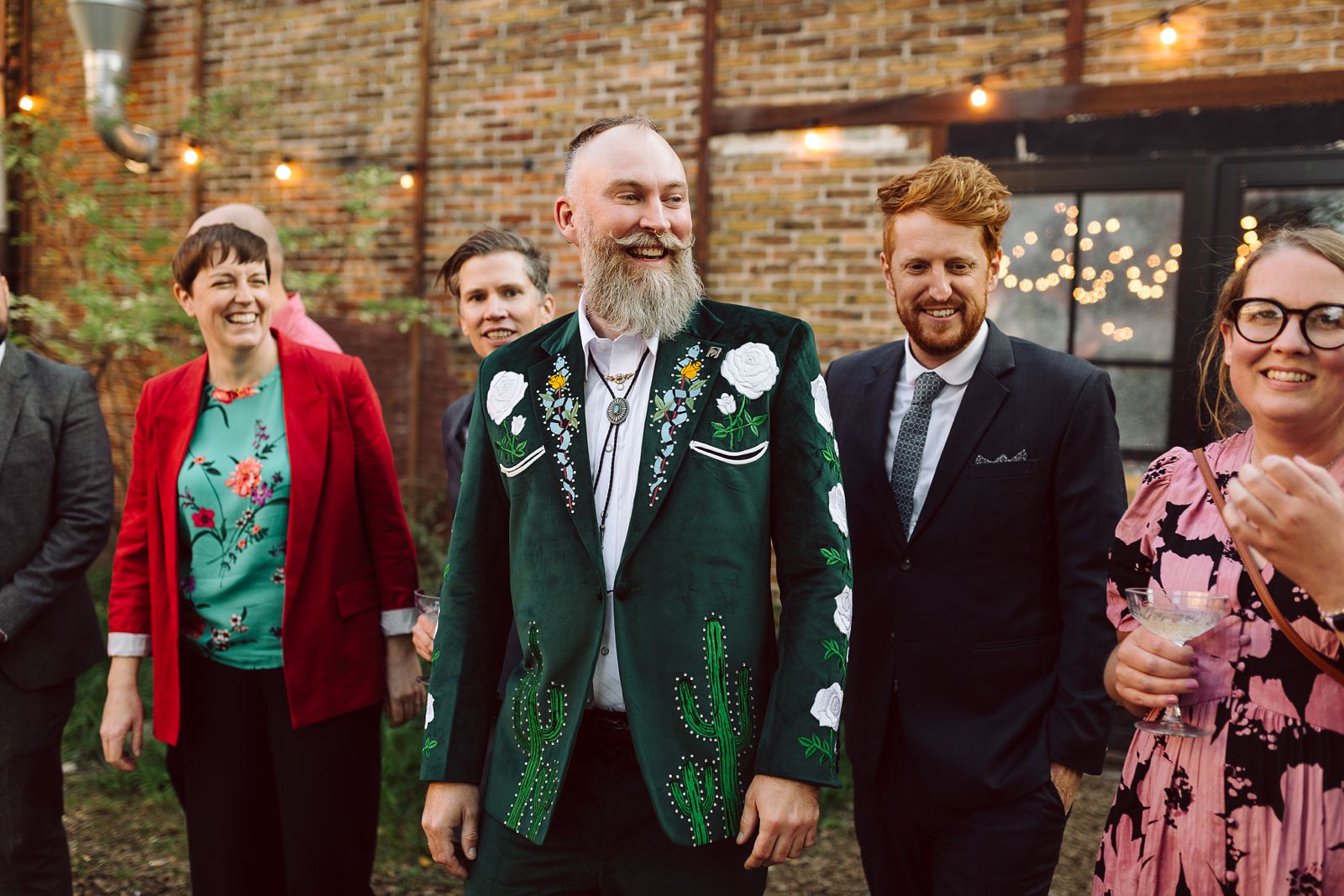 Wedding guests gathered together for a joyful group photo at Reffen in Copenhagen