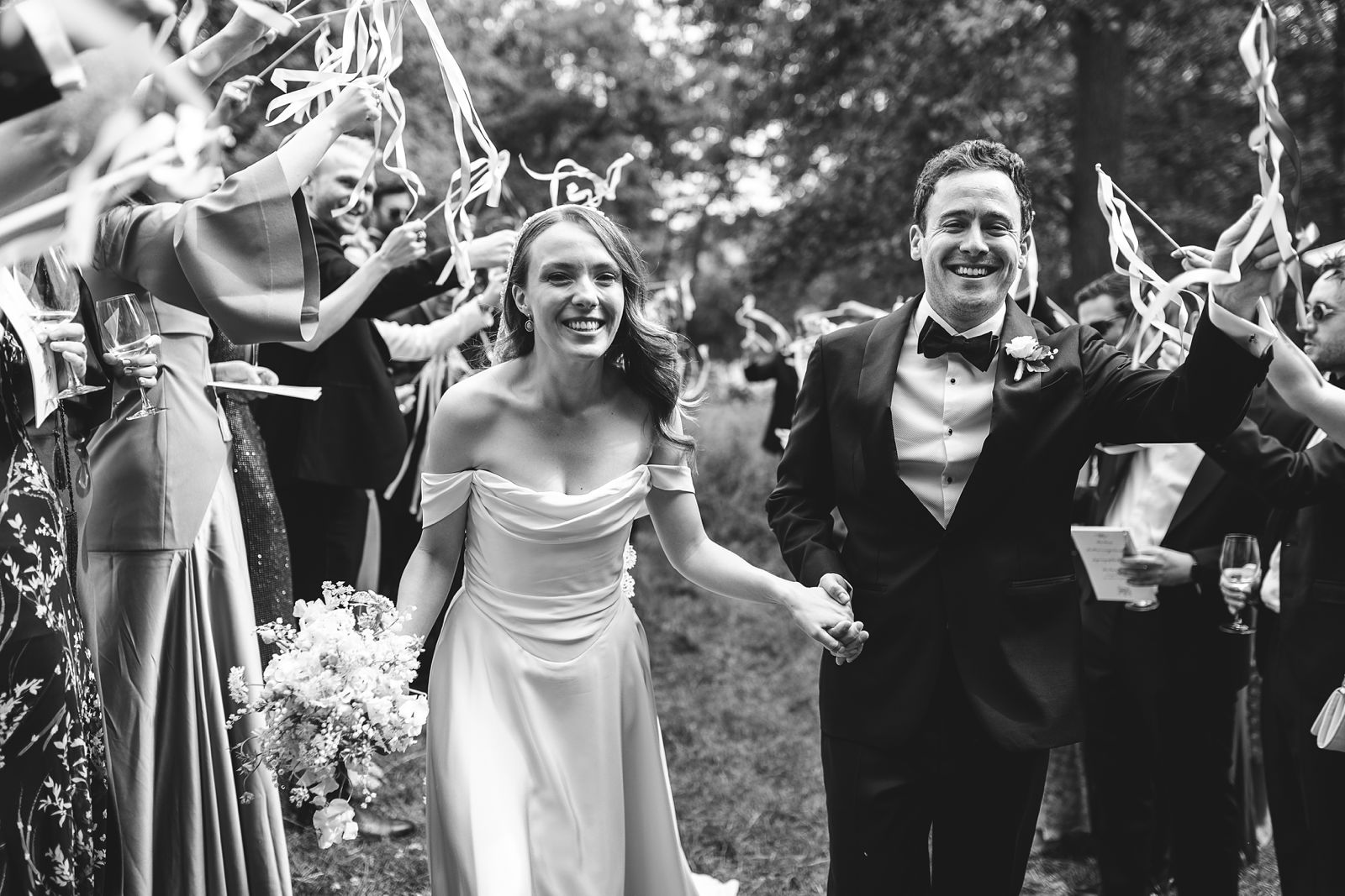 Wedding exit with guests waving ribbon wands in Dyrehaven, Copenhagen