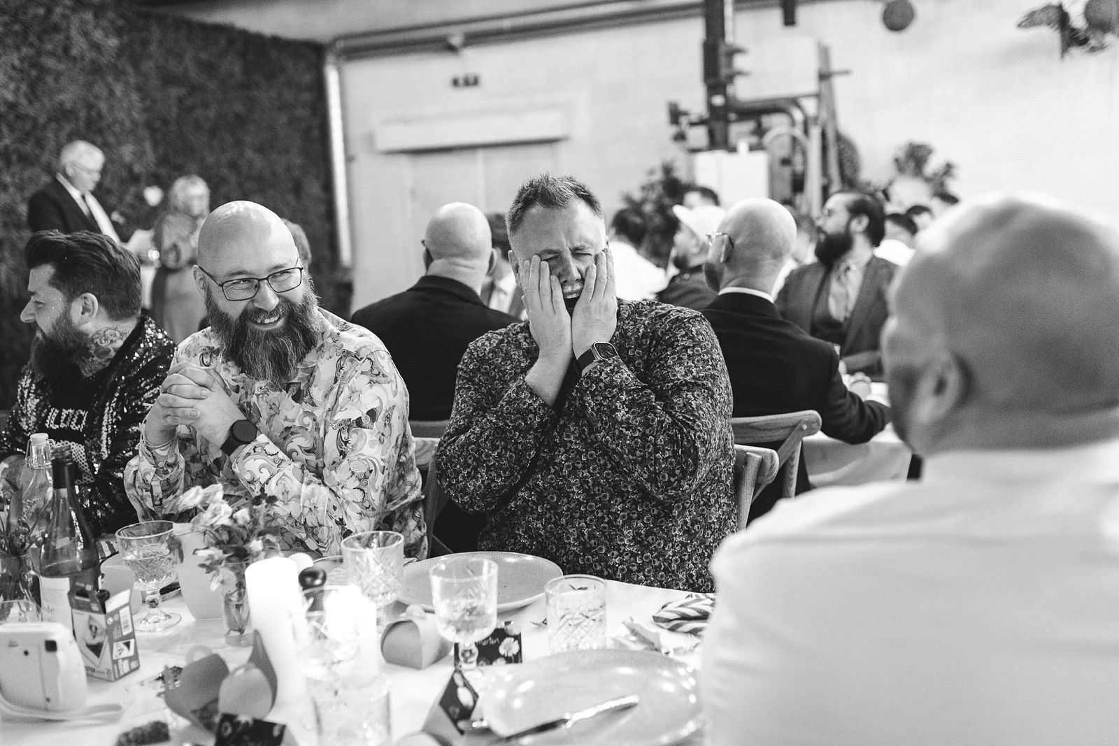 Guests laughing during a heartfelt wedding speech at a Reffen Copenhagen wedding reception.